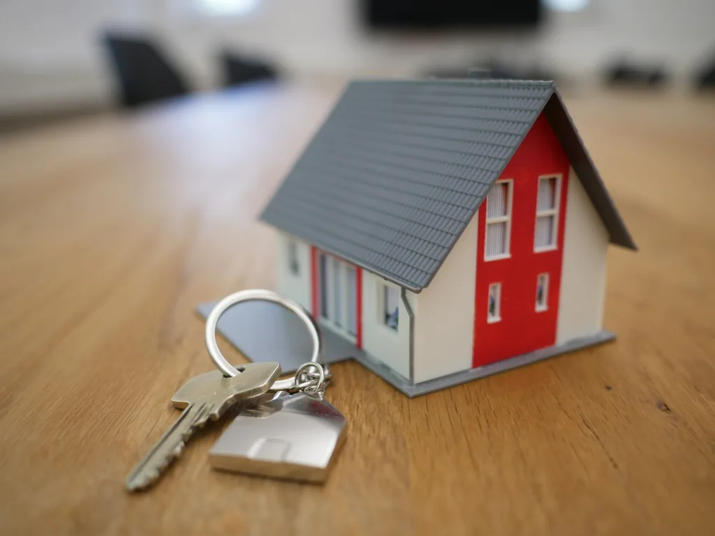 A house is beside a key to represent an approved mortgage.