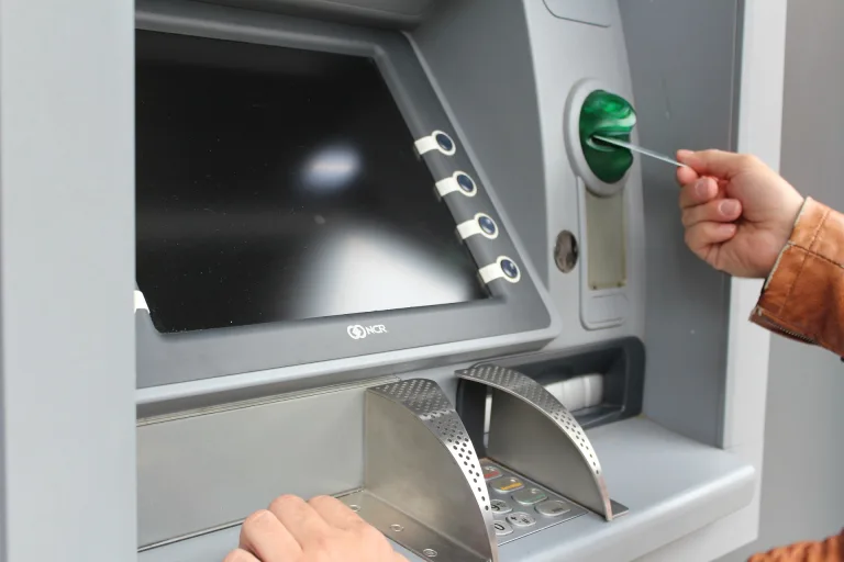 A person uses an ATM to access their chequing or savings account.