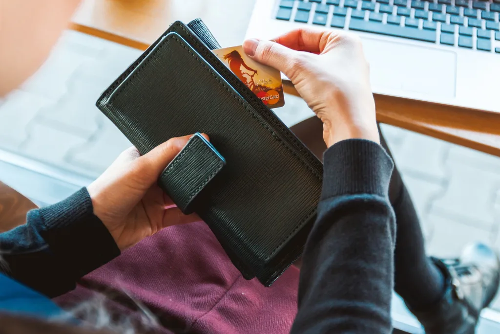 Woman takes credit card out of her wallet to make online purchase