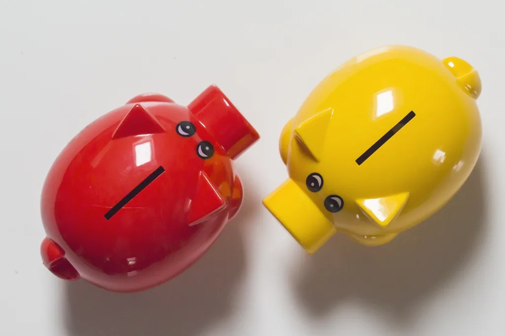 A red and a yellow piggy bank to represent saving on low interest mastercard credit cards