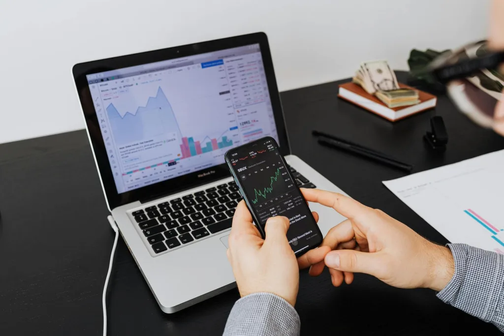 A man intently examines stock market data on his smartphone, showcasing modern investment practices.