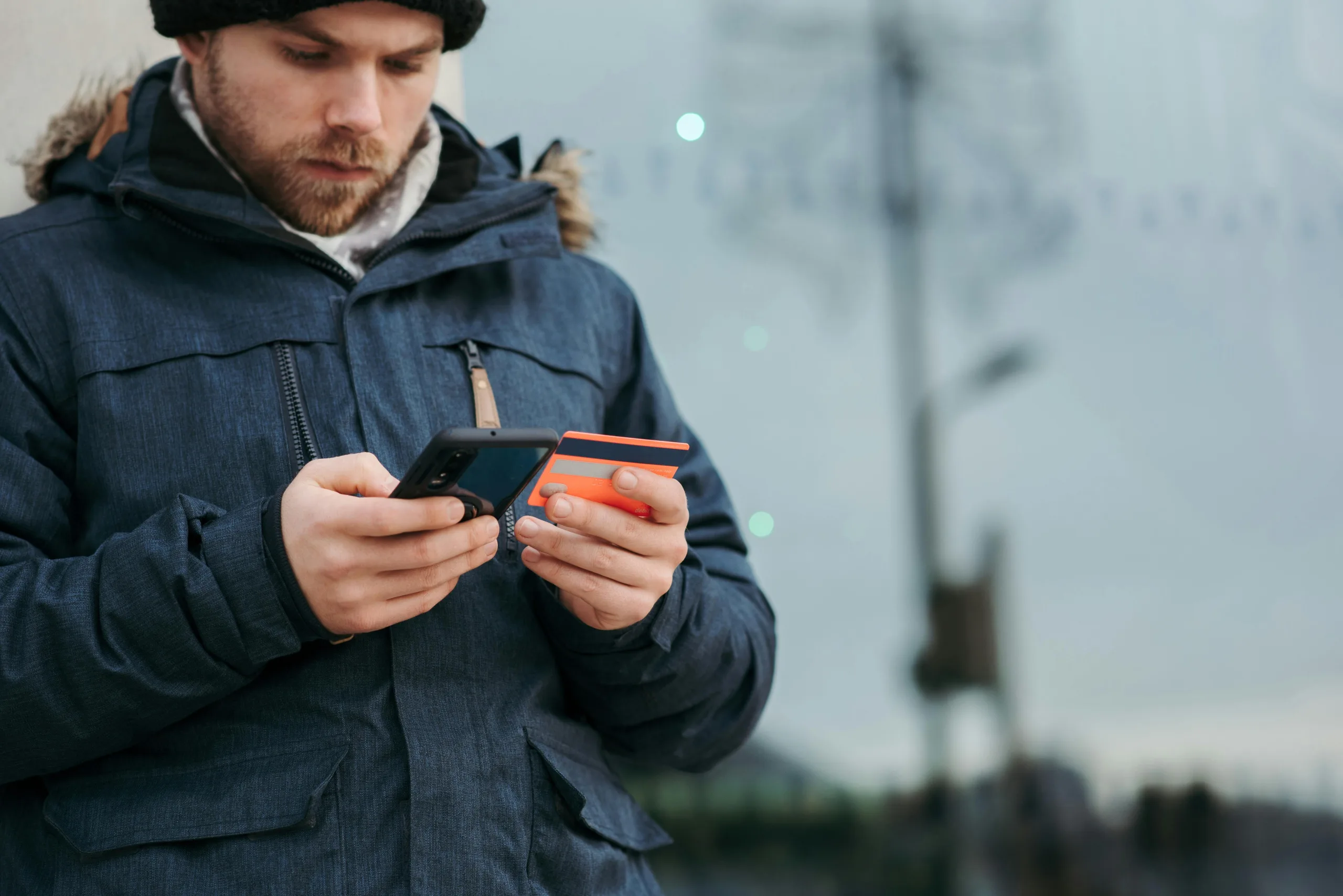 Man uses credit card to make purchase on his phone.