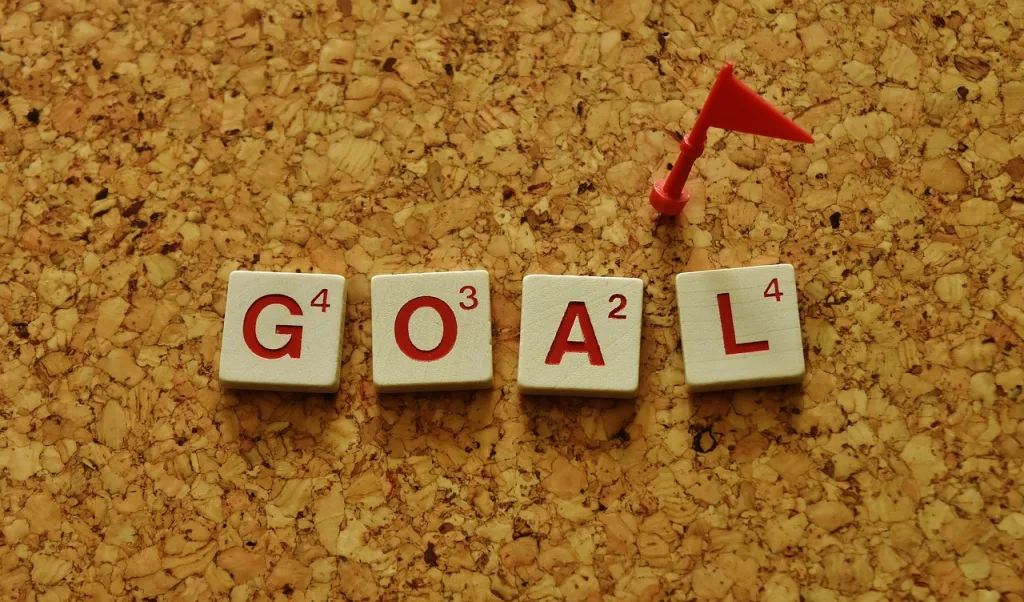 Wooden blocks spelling the word "goal" arranged on a cork board, showcasing a creative and motivational display.