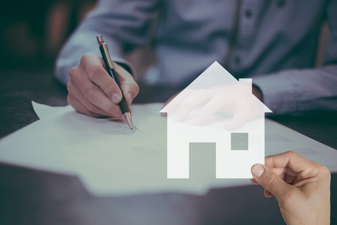 A man signing a contract, symbolized by a house icon, representing a real estate transaction or home purchase agreement.