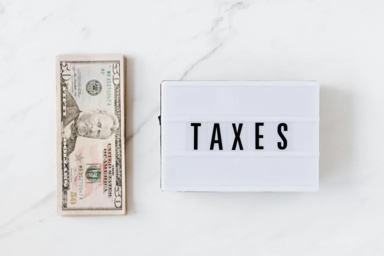 A close-up view of tax documents and forms arranged neatly on a white marble surface, symbolizing financial responsibility.