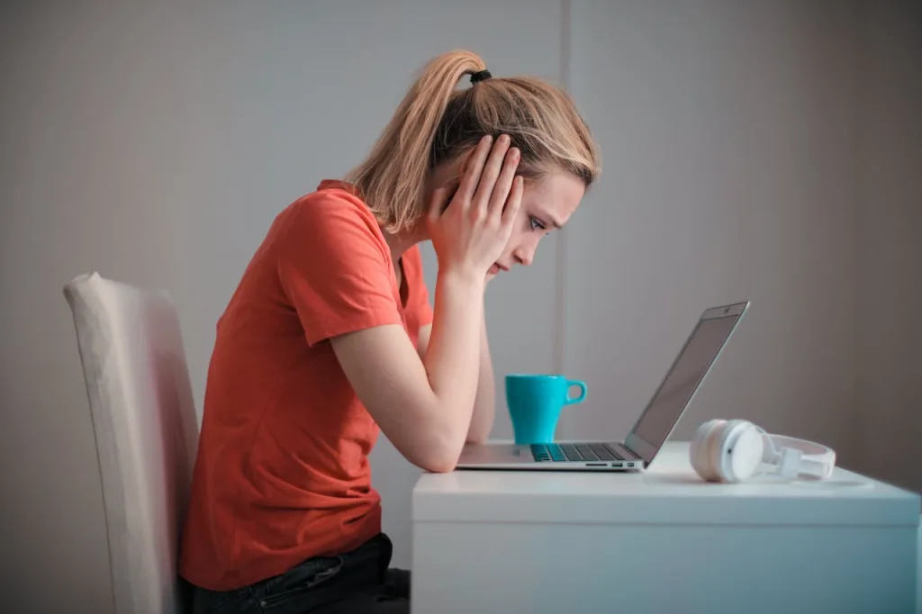 Woman looking confused in front of a laptop about how to switch a bank account