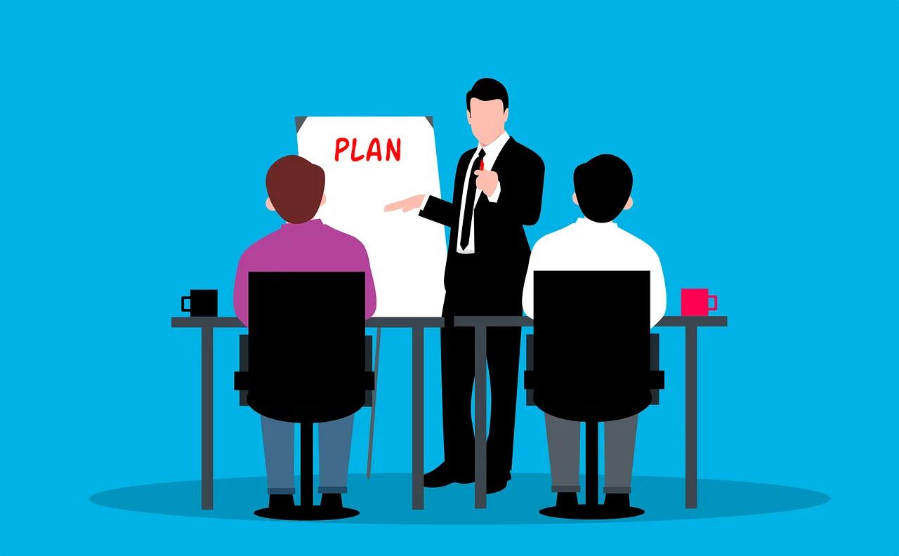 A group of business professionals seated at a table, discussing a strategic plan displayed on a board.